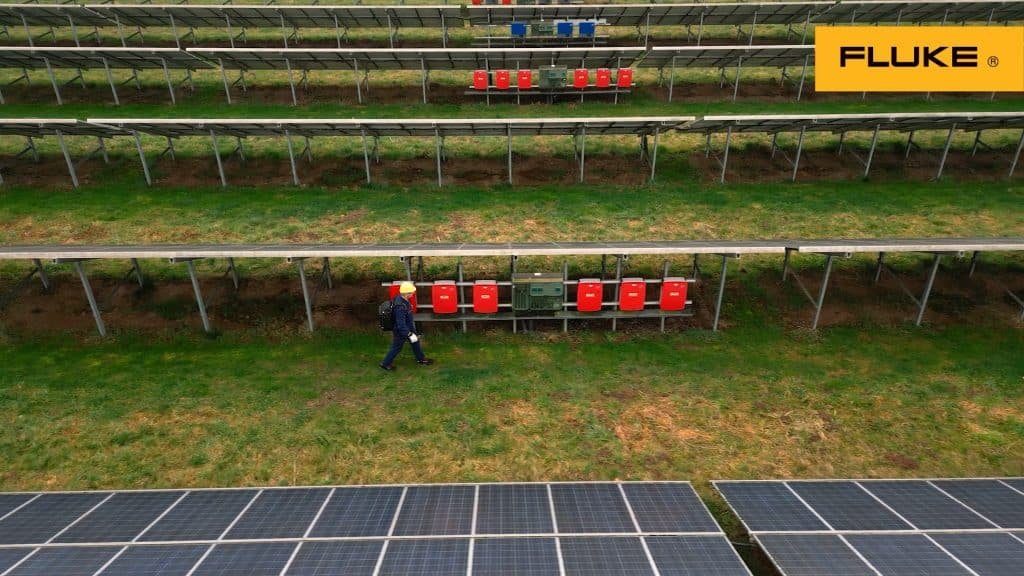een technicus loopt door een solar veld